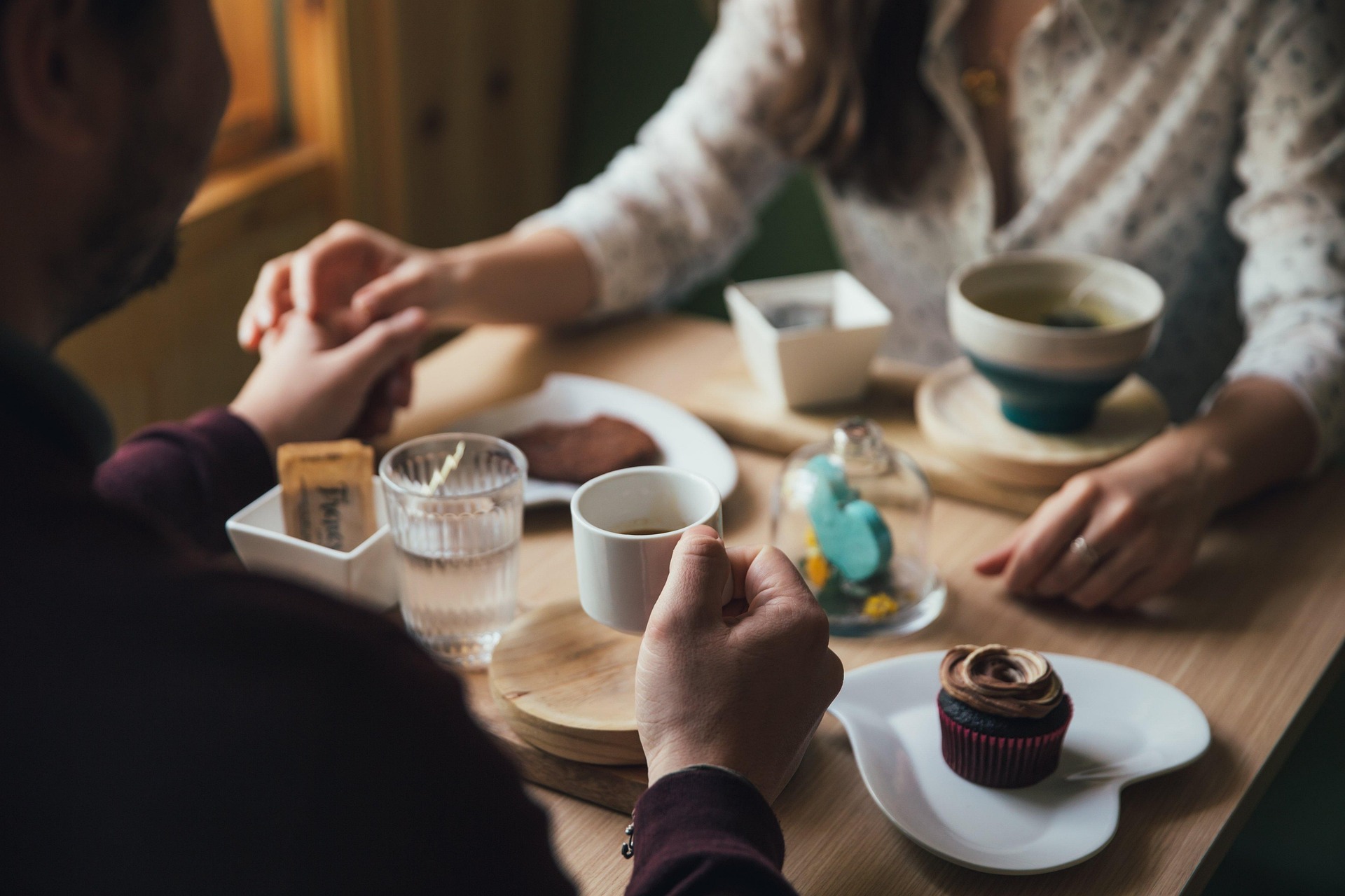 Koppel aan tafel met koffie en gebak.